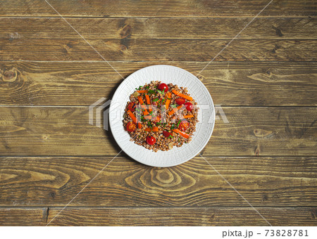 Salad with buckwheat and vegetables on a white plate 73828781