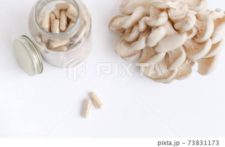 mushrooms and a bottle with mushroom capsules supplement mushrooms and a bottle with mushroom capsules supplement 73831173
