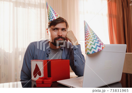 young man sitting at the table and talking by video call to friends. 73831965