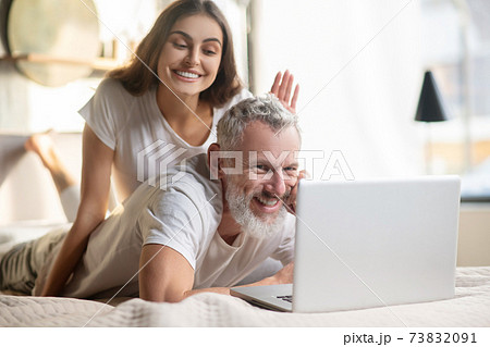 Man behind laptop and woman who distracts him Man behind laptop and woman who distracts him 73832091