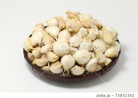 バラバラにほぐしたニンニクのザル盛り、たくさん 73832302