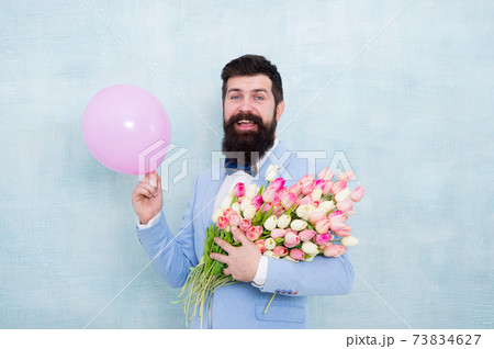 Bearded man hipster with flower bouquet. Greetings 73834627