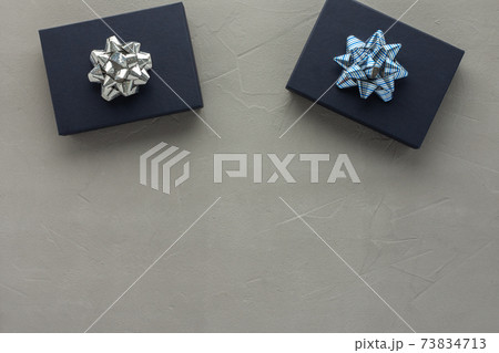Blue gift boxes with a bow on a gray concrete background Blue gift boxes with a bow on a gray concrete background 73834713