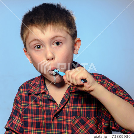 Handsome boy brushing teeth, daily procedure, baby in pajamas, dental care. Handsome boy brushing teeth, daily procedure, baby in pajamas, dental care. 73839980