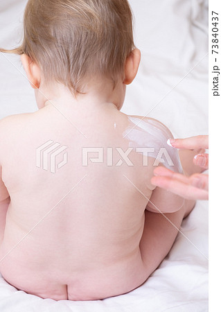 Back and ass of a faceless Caucasian naked baby, a mother without a 73840437