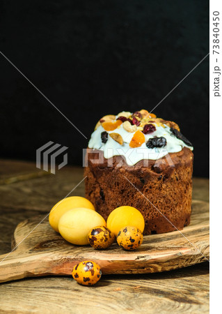 Easter cake and eggs on a wooden board. Still life on a black Easter cake and eggs on a wooden board. Still life on a black 73840450