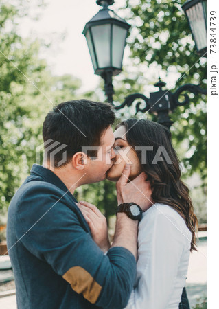 Couple in love. Valentines day celebration, love and dating outdoor concept. Happy loving couple walking on the city street, hugging and kissing Couple in love. Valentines day celebration, love and dating outdoor concept. Happy loving couple walking on the city street, hugging and kissing 73844739