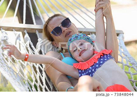 Woman with child swing on hammock in street 73848044