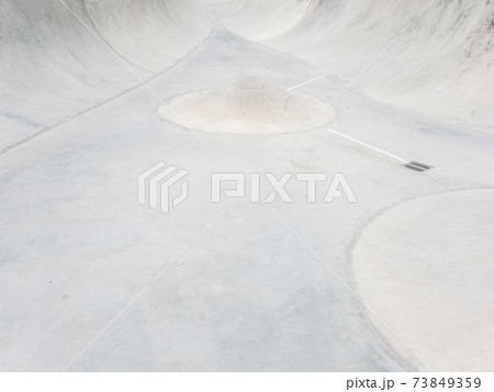 Empty concrete skatepark with a cone obstacle in the middle. Full screen photo Empty concrete skatepark with a cone obstacle in the middle. Full screen photo 73849359