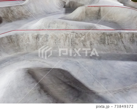 Concrete skate park with bowls and ramps. Full screen photo Concrete skate park with bowls and ramps. Full screen photo 73849372