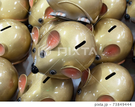 The ceramic piggy bank of the green mouse lies on other mice from above. Symbol of 2020 73849444