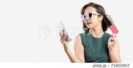 Asian woman with glasses shopping by phone and hold credit card 73850907