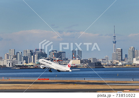 羽田空港第2ターミナルを離陸したjal機と東京スカイツリー の写真素材