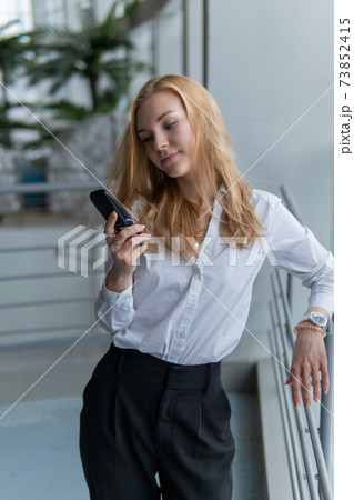 woman talking on the phone. Joyful with a lovely smile, wellbeing concept, on against the window, by the railing woman talking on the phone. Joyful with a lovely smile, wellbeing concept, on against the window, by the railing 73852415