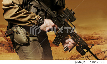 Soldier in military outfit with rifle. 73852622