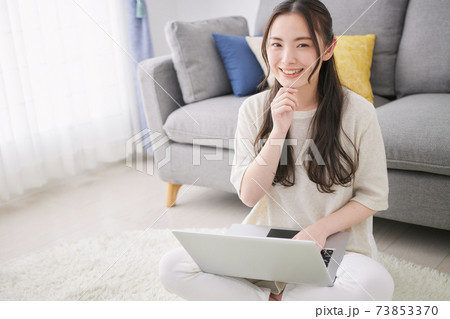 リビングでパソコンを使う若い女性 リビングでパソコンを使う若い女性 73853370