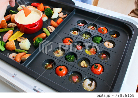 ホットプレートでアヒージョとチーズフォンデュをする家族の食卓風景 ホットプレートでアヒージョとチーズフォンデュをする家族の食卓風景 73856159