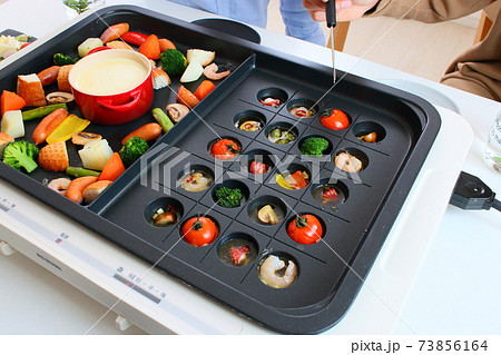 ホットプレートでアヒージョとチーズフォンデュをする家族の食卓風景 ホットプレートでアヒージョとチーズフォンデュをする家族の食卓風景 73856164