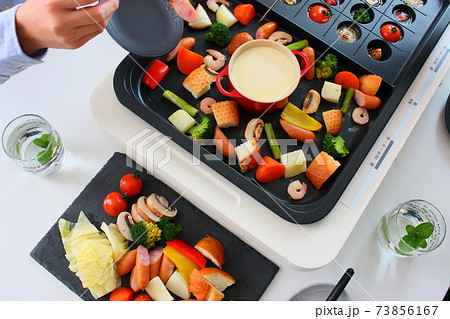 ホットプレートでアヒージョとチーズフォンデュをする家族の食卓風景 ホットプレートでアヒージョとチーズフォンデュをする家族の食卓風景 73856167