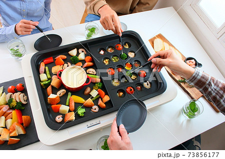 ホットプレートでアヒージョとチーズフォンデュをする家族の食卓風景 ホットプレートでアヒージョとチーズフォンデュをする家族の食卓風景 73856177