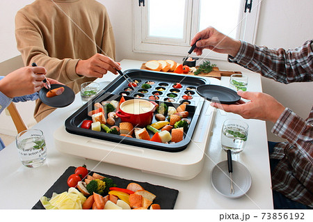 ホットプレートでアヒージョとチーズフォンデュをする家族の食卓風景 ホットプレートでアヒージョとチーズフォンデュをする家族の食卓風景 73856192