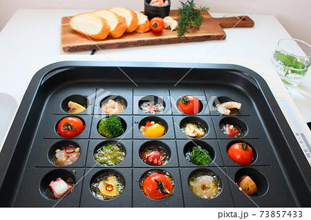 ホットプレートでアヒージョュをする家族の食卓風景 ホットプレートでアヒージョュをする家族の食卓風景 73857433