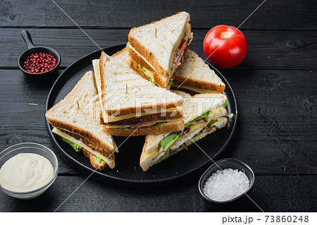 Sandwich bread tomato, lettuce and yellow cheese, on black wooden background Sandwich bread tomato, lettuce and yellow cheese, on black wooden background 73860248