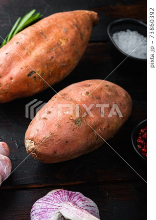 Sweet potato or batat with herbs on old wooden table Sweet potato or batat with herbs on old wooden table 73860392