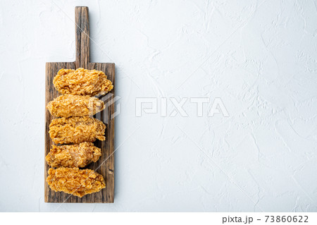 Spicy deep fried breaded chicken wings on white background, top view, with copy space Spicy deep fried breaded chicken wings on white background, top view, with copy space 73860622