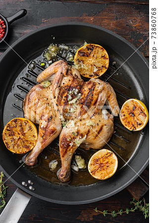 Grilled whole chicken, with chimichurri sauce, on old wooden table, top view 73860768
