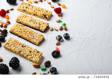 Various healthy granola, muesli and cereal bars with space for text, on white background Various healthy granola, muesli and cereal bars with space for text, on white background 73860848