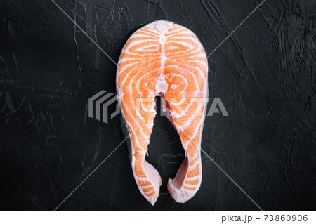 Raw salmon steak, over black background, flat view with space for text 73860906