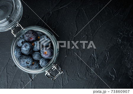 Blueberry in glass jar, flat lay with space for text, on black background 73860907
