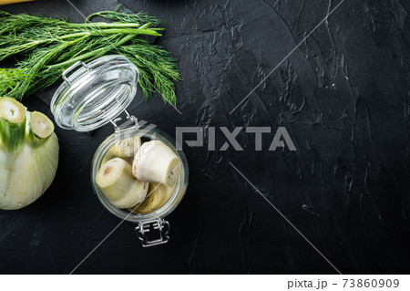 Artichoke hearts marinated in olive oil, on black textured background, top view with space for text 73860909