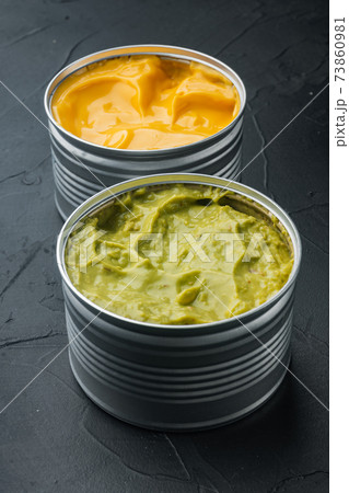 Canned cheese and guacamole sauce, on black background 73860981