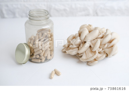 mushrooms and a bottle with mushroom capsules supplement 73861616