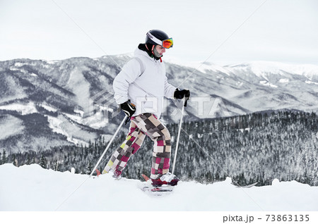 Skier wearing ski equipment spending time on mountain slopes in winter season 73863135