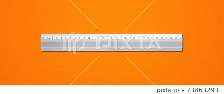 Metal ruler isolated on orange background 73863293