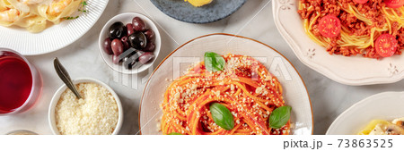 Italian food panorama. Spaghetti, olives, and Parmesan cheese, shot from the top Italian food panorama. Spaghetti, olives, and Parmesan cheese, shot from the top 73863525