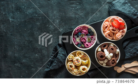rolled ice creams in cone cups on dark background rolled ice creams in cone cups on dark background 73864670