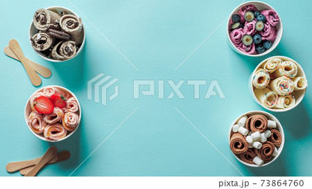 rolled ice creams in cone cups on blue background 73864760