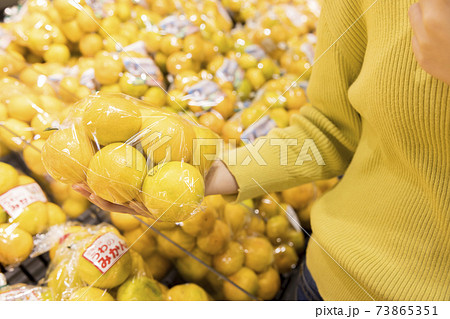 スーパーでみかんを手にする女性買い物客手元 スーパーでみかんを手にする女性買い物客手元 73865351
