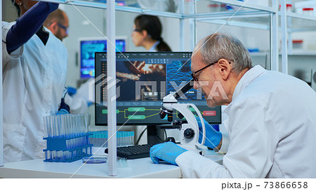 Medical research scientist conducting DNA experiments under microscope 73866658