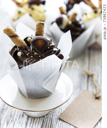 Chocolate cupcakes on white wooden background Chocolate cupcakes on white wooden background 73867423