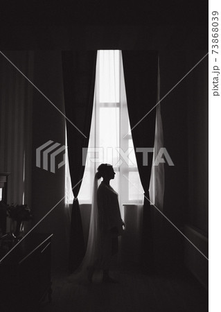 Silhouette of bride open curtains in hotel. Big window 73868039