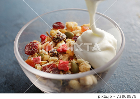 ヨーグルトを注いでいる朝食のフルーツグラノーラ 73868979