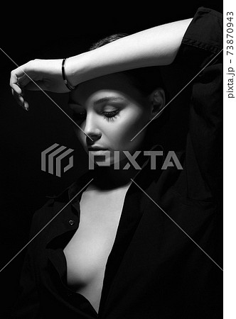black and white portrait of young beautiful woman under shadow 73870943
