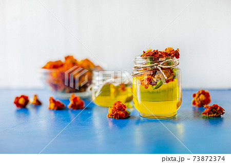 Processing of dried flowers marigolds. Bottle of Chornobrivtsi essential oil . 73872374