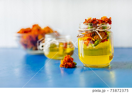 Processing of dried flowers marigolds. Bottle of Chornobrivtsi essential oil . Processing of dried flowers marigolds. Bottle of Chornobrivtsi essential oil . 73872375