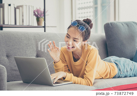 Beautiful young asian woman lying down and using computer laptop Beautiful young asian woman lying down and using computer laptop 73872749